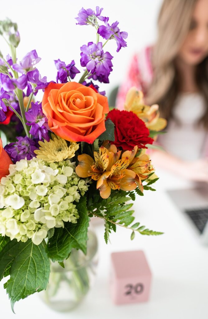 a close up of a bouquet of flowers and a person blurry in the background